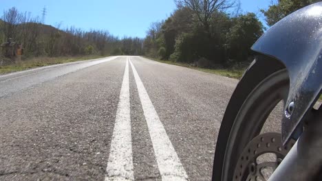 riding motorcycle, front wheel view, twisty countryside road, cornering through curves, time lapse video