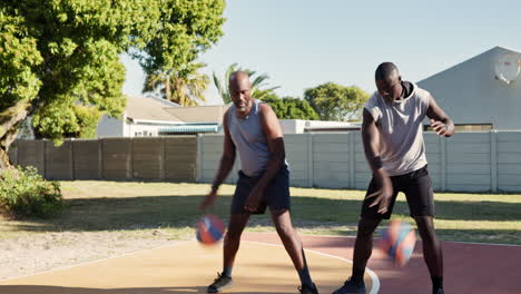 two men playing basketball outdoors
