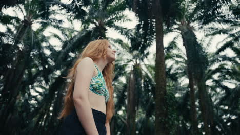 woman in bikini top among palm trees