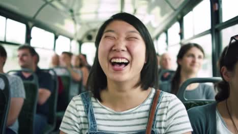 a young woman beams with joy while surrounded by friends on a bus filled with happy passengers. the atmosphere is filled with excitement and laughter as they enjoy their trip together.