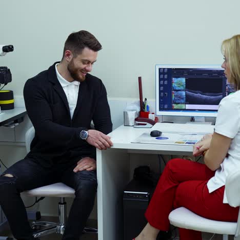 man at appointment in modern clinic. doctor checking young man patient eyes in medical office