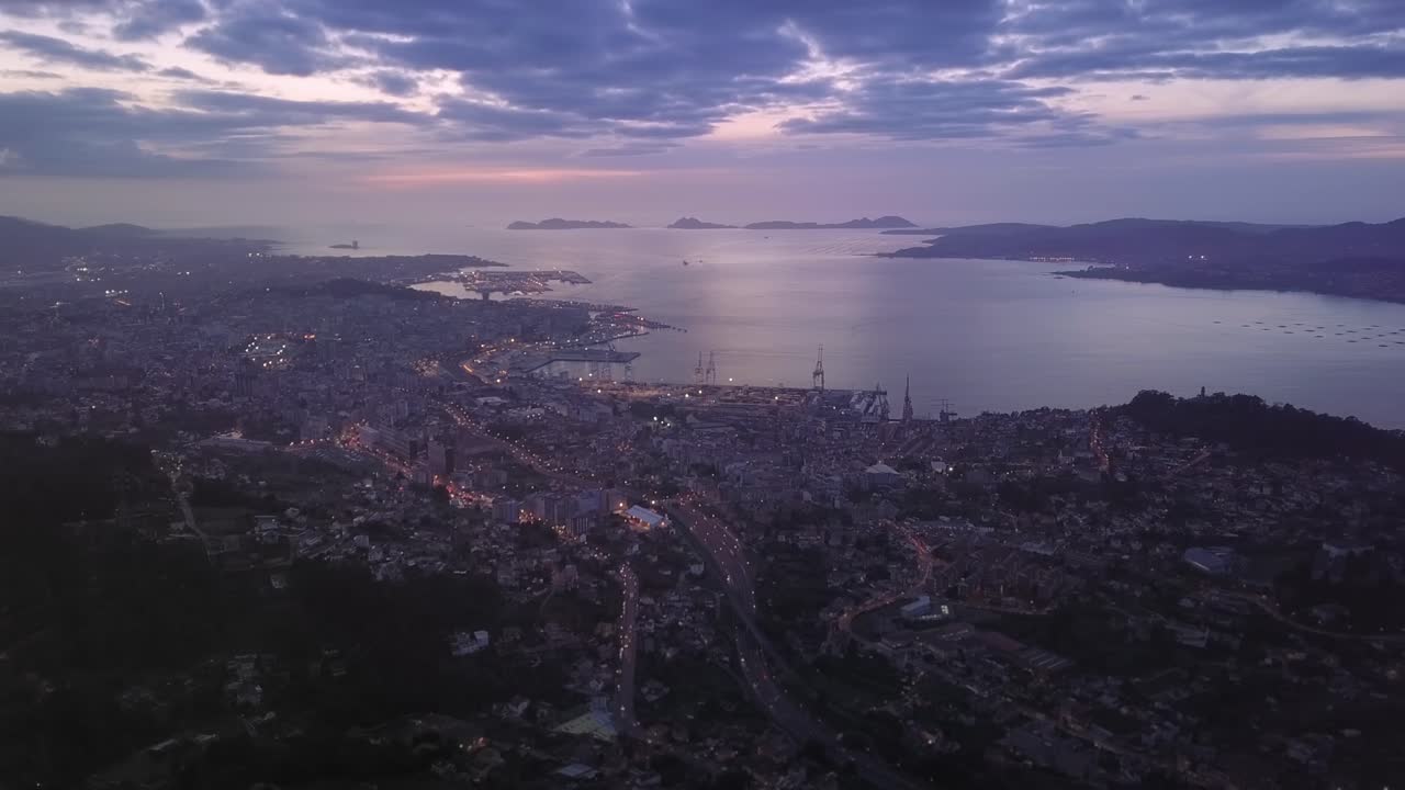 Aerial timelaps after sunset of the city scape of Vigo with the highway and the atlantic Cies islands in th background. Galicia, Spain