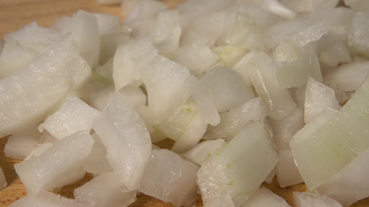 나무 절단판 에 있는 양파 큐브 를 근접 으로 찍는 것