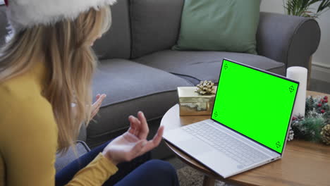 feliz mujer caucásica teniendo navidad llamada de video portátil con pantalla verde, cámara lenta