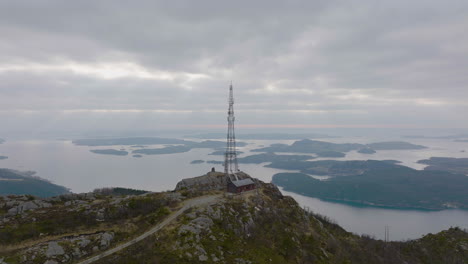 mast tower, antennas for transmission mobile telecommunication signal on top of hill - aerial birds eye, norway