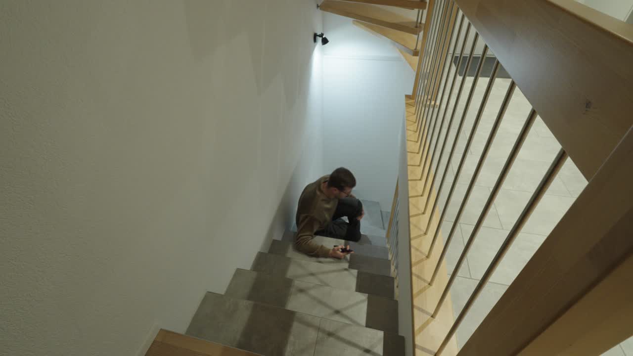 A man walks down a staircase while staring at his smartphone, losing attention and stumbling, highlighting the dangers of distraction, unsafe phone use, and increased fall risk on stairs