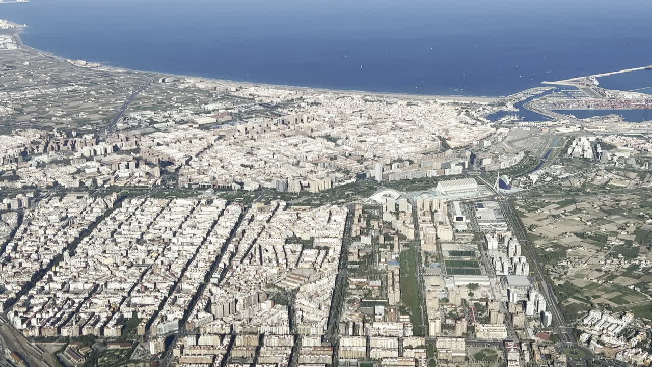 Aerial side view of Valencia City center, with a view of the harbor and the north coast in a summer morning. 4K