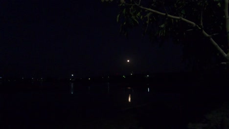 4k video of lake with full moon and it's reflection during night. travel background for any coastal region or vacation.