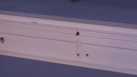 instalación de un soporte metálico en un perfil de aluminio