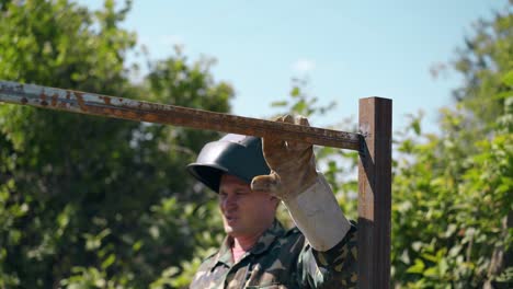 builder checks fence quality with hammer and hangs on rail