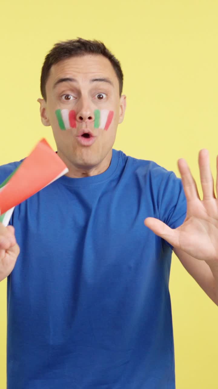 Passionate italian supporter screaming and waving a national flag