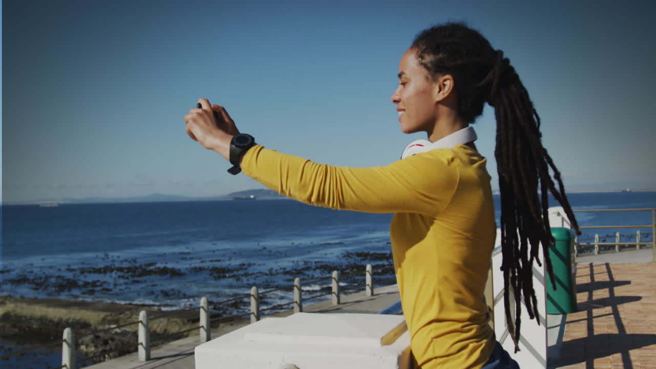 Animation of smiling biracial woman taking photo on promenade