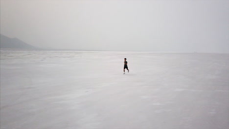 dramática antena de un joven corriendo en el desierto de sal del desierto de utah