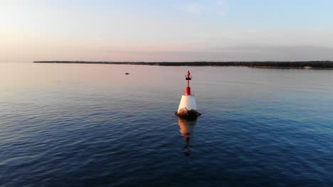 an anchored float, navigation marker in the calm sea on sunset