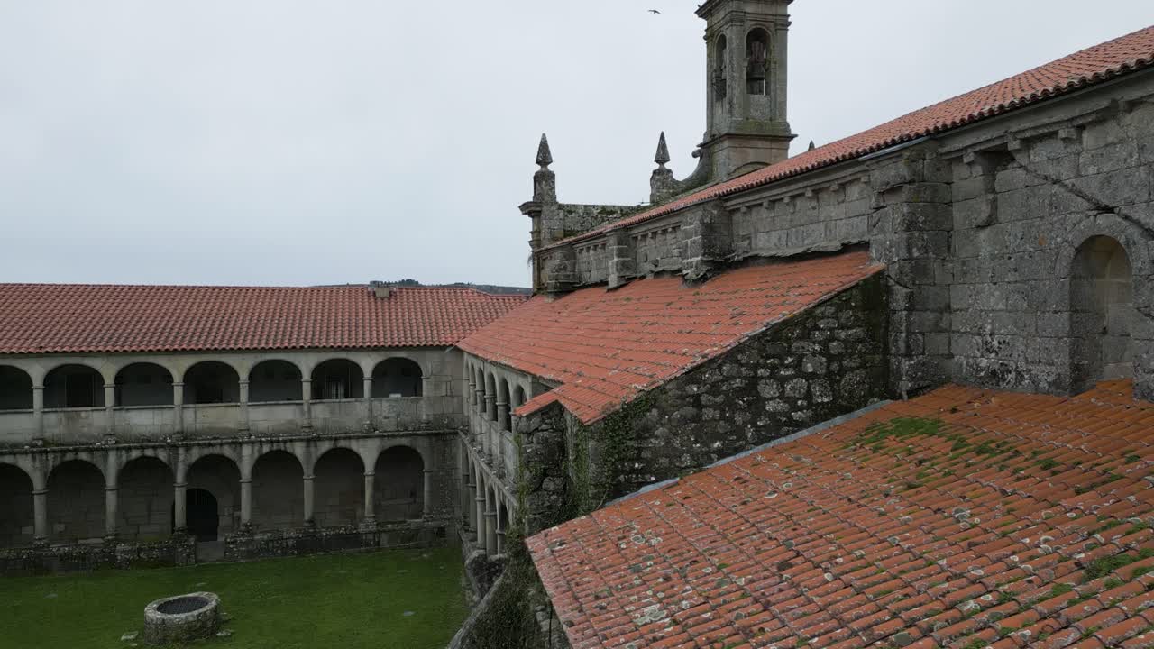 primer plano aéreo inclinado hacia la torre de piedra tallada del monasterio de santa maría de xunqueira