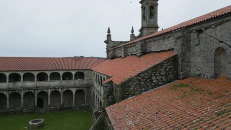 closeup aerial tilt up to carved stone tower of santa maria de xunqueira monastery