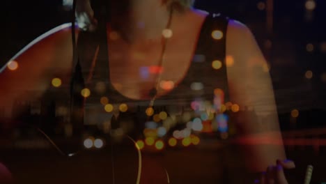 animation of cityscape over caucasian female singer playing guitar