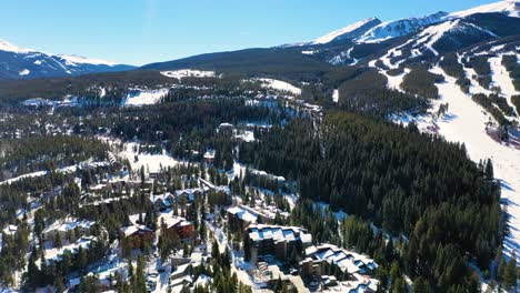 pueblo de montaña rocosa con casas y pistas de esquí en la fría nieve del invierno