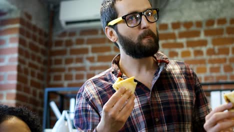 colleagues in office eating pizza together