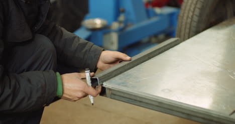 man working at metal industry cutting and measuring metal parts at workshop 2