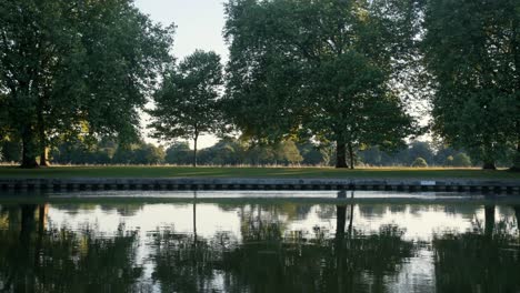 Looking-over-the-Thames-River-at-sunset-into-a-field-in-the-English-countryside-near-Windsor-Castle-in-summer