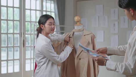 fashion designers collaborating on a new coat design