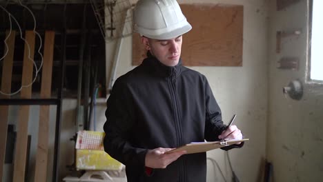 professional architect writing down details of home structure for reconstruction