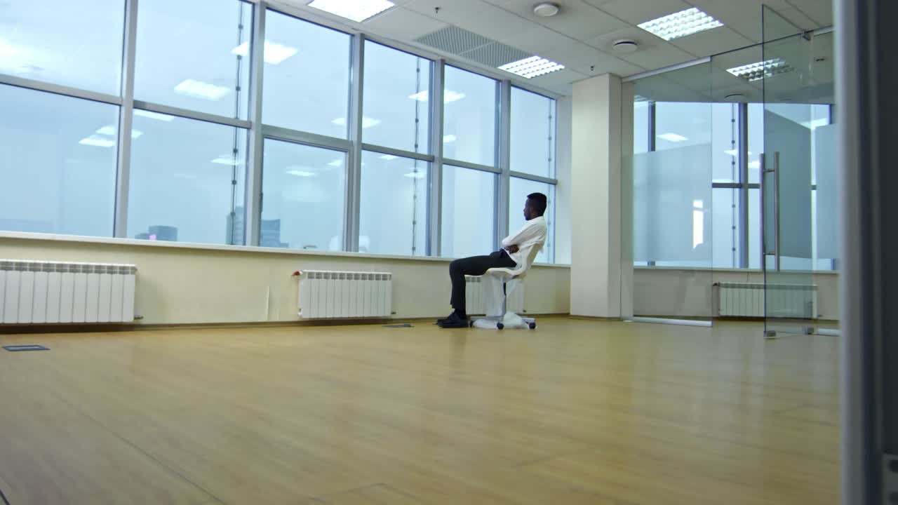 사업가 가 새 빈 사무실 의 창문 을 통해 도시 파노라마 를 바라보고 있다