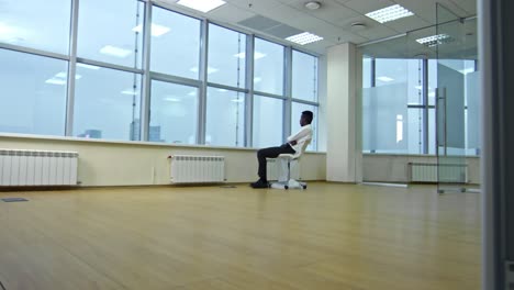 un hombre de negocios observando el panorama de la ciudad a través de la ventana de una nueva oficina vacía.