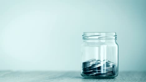 close up money coin falling into glass jar , money saving , a donation or business financial growth concept , 4k dci resolution , vintage retro color tone