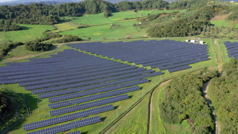 Aerial:-Panoramic-panning-shot-of-clouds-covering-solar-power-plant-on-green-field