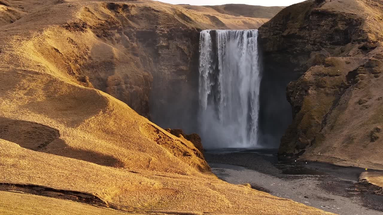 Skógafoss waterfall flowing through volcanic valley in south Iceland