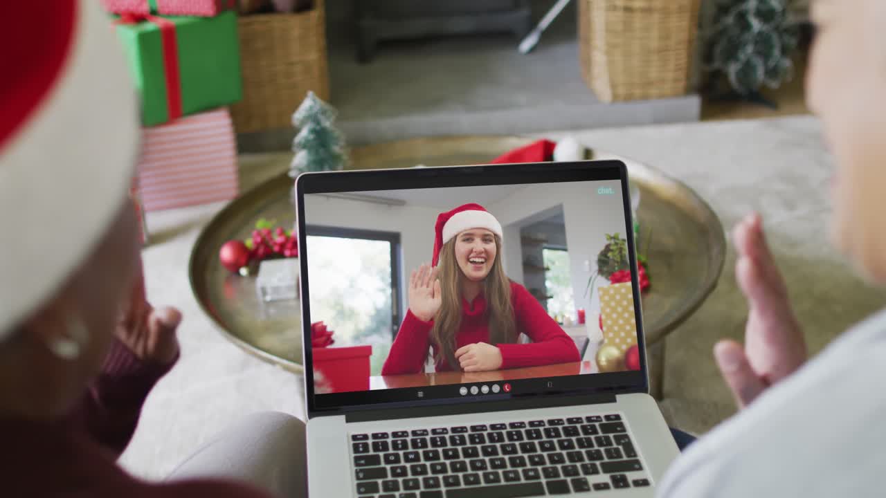 diversas amigas mayores que usan una computadora portátil para una videollamada de navidad con una mujer en la pantalla