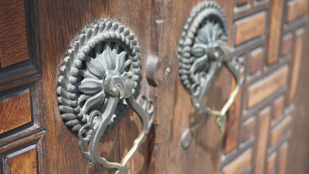 manijas de puerta ornamentales en una puerta de madera
