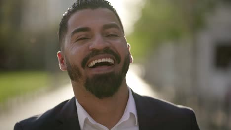 cheerful businessman laughing and looking at camera outdoor