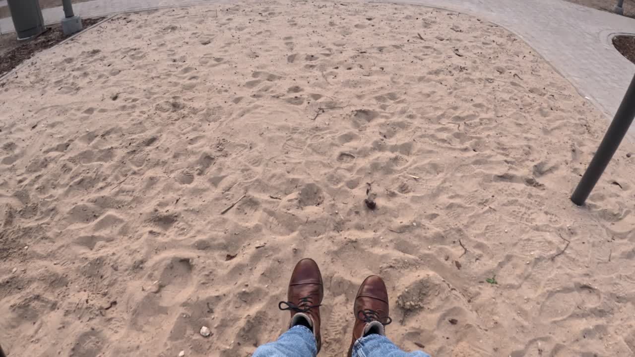 A POV shot from a grown-up’s perspective while swinging at a playground, capturing a nostalgic and freeing moment.