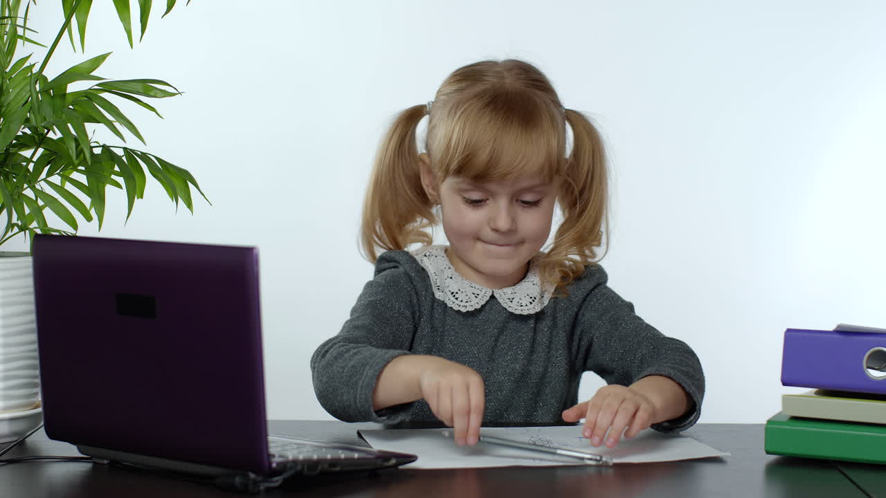 niño preescolar niña aprendizaje a distancia en línea en el hogar. niño estudiando usando computadora portátil digital