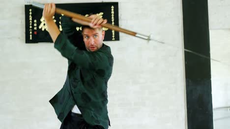 un luchador de kung fu practicando artes marciales con la espada 4k