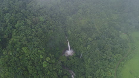 aerial over lush fog covered la fortuna waterfall costa rica rain forest, 4k