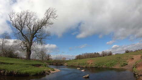 a sunny windy day on the river arrow in warwickshire, england as clouds roll over head