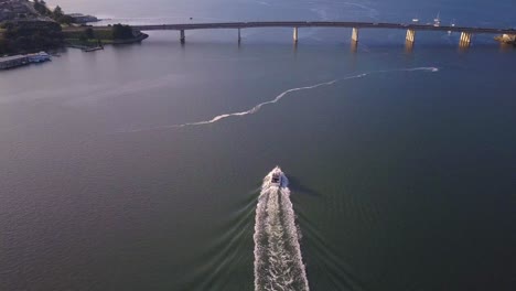 aerial speed boat chasing and following by the drone at golden hour sunrise