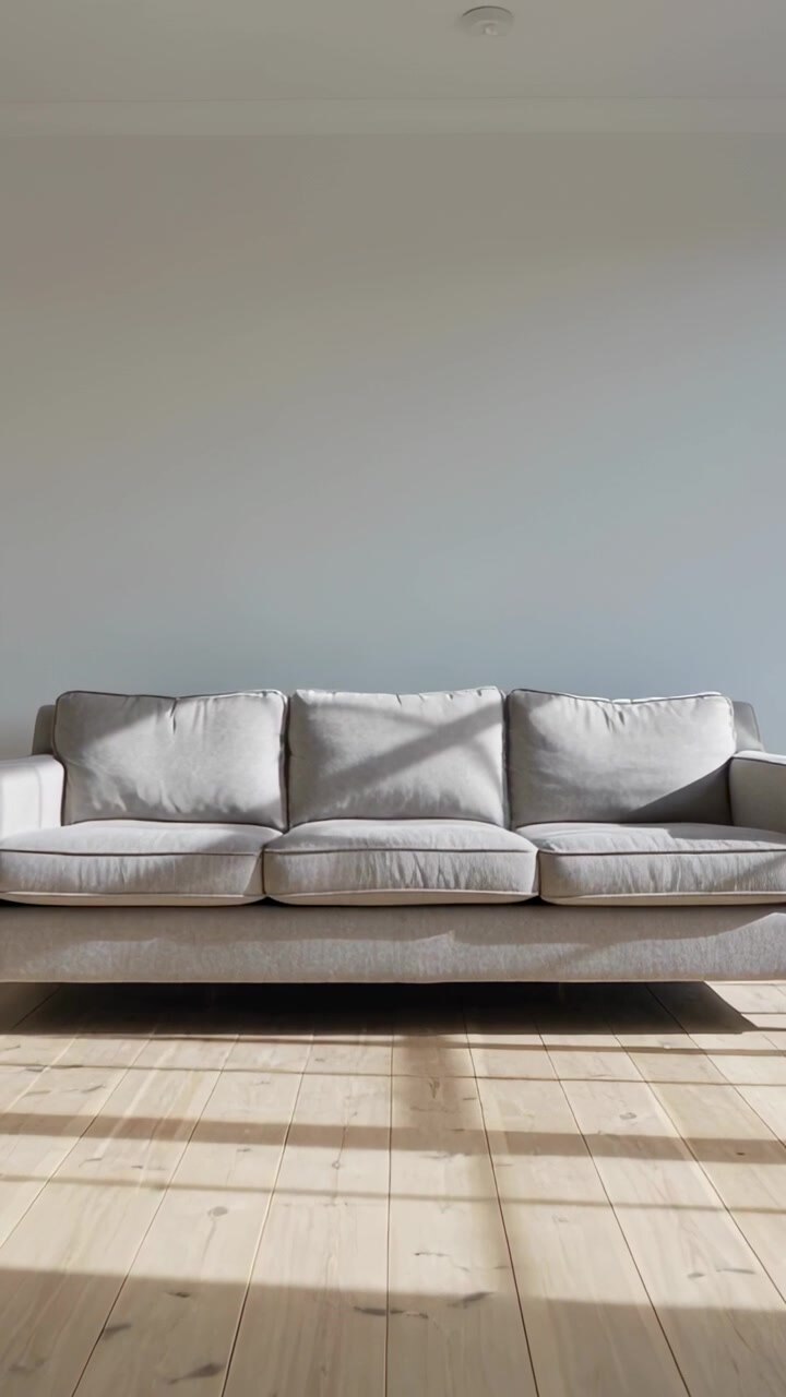 Vertical video: Shifting sunlight moving across wood floor and gray sofa as sun moves, casting grid
