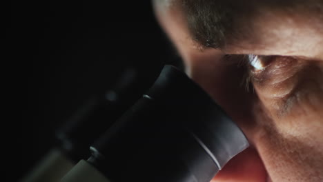 side view of of a scientist working with a microscope in the lab