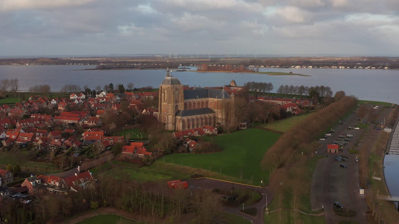 The old city Veere with historical buildings next to a canal and a lake. Drone shot