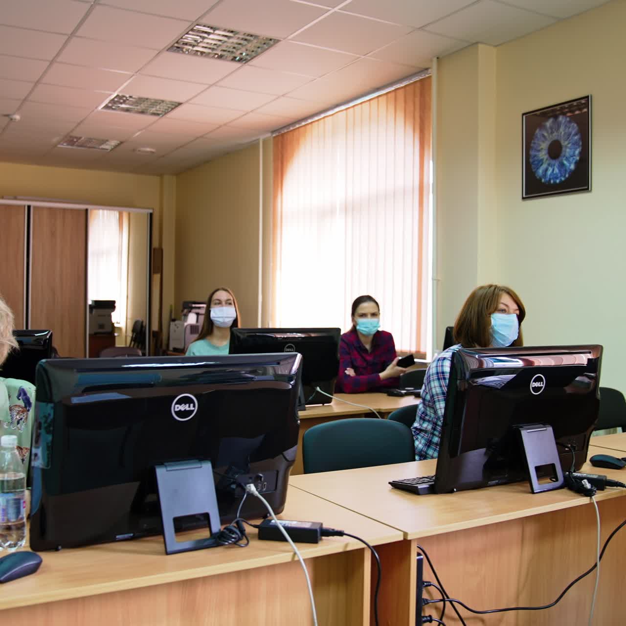 Course on ophthalmology in the modern university. Students wearing masks sit at the desks in front of computers
