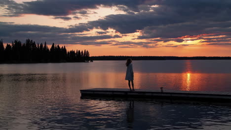 woman on a pier at sunset