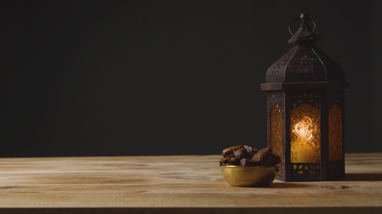 Inquadratura fissa di una mano che beve acqua su un tavolo per il Ramadan