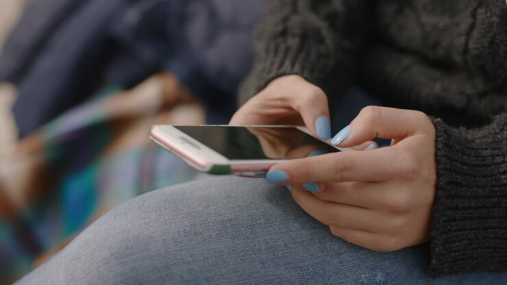 woman hands using smartphone typing messages texting online browsing social media enjoying sitting on seaside beach relaxing