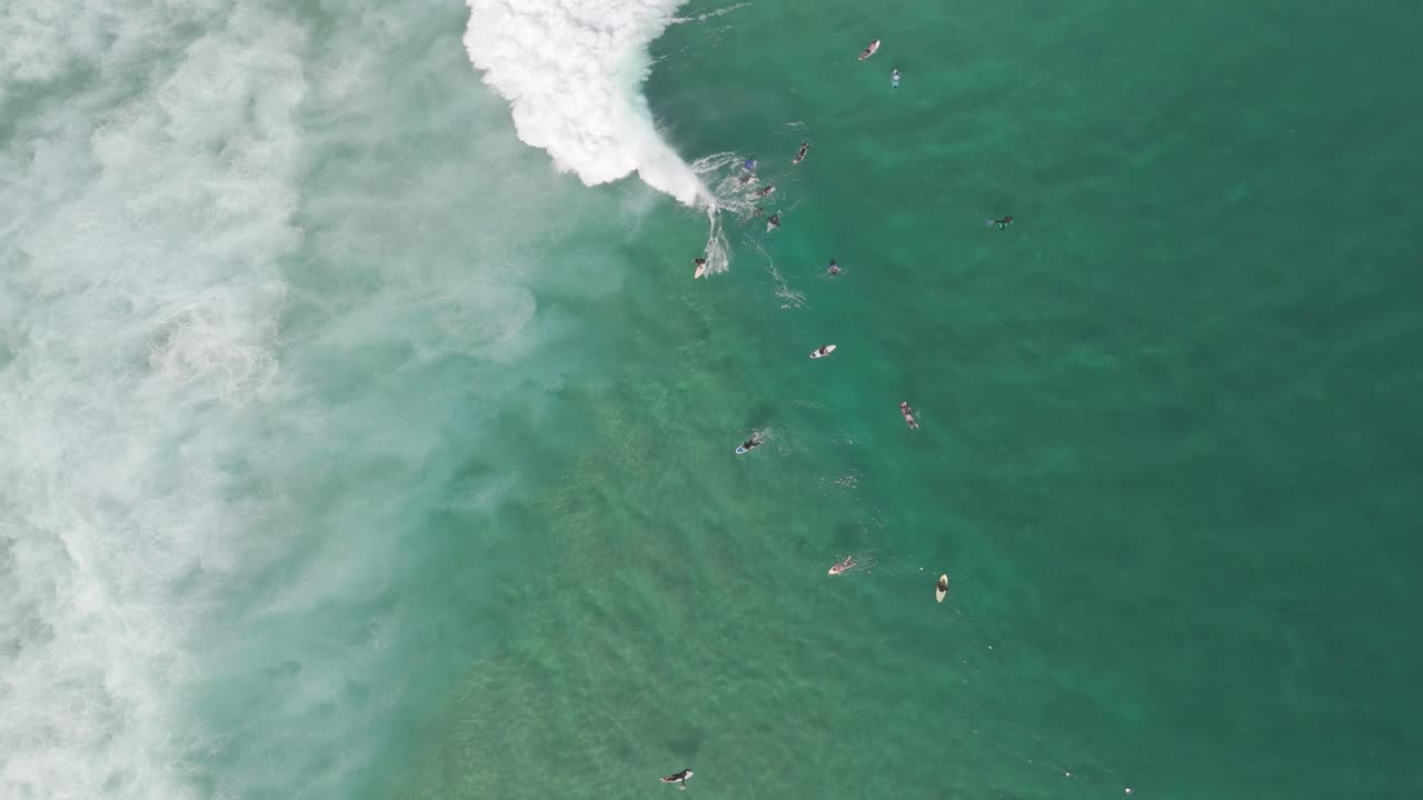 Vista aerea di surfisti che cavalcano le onde nell'oceano turchese