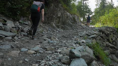 Couple-of-trekkers-backpacking-walking-on-mountain-trail-in-Valmalenco,-Italy